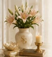Vase of lilies with Sunita Gupta crest, candle and sacred books